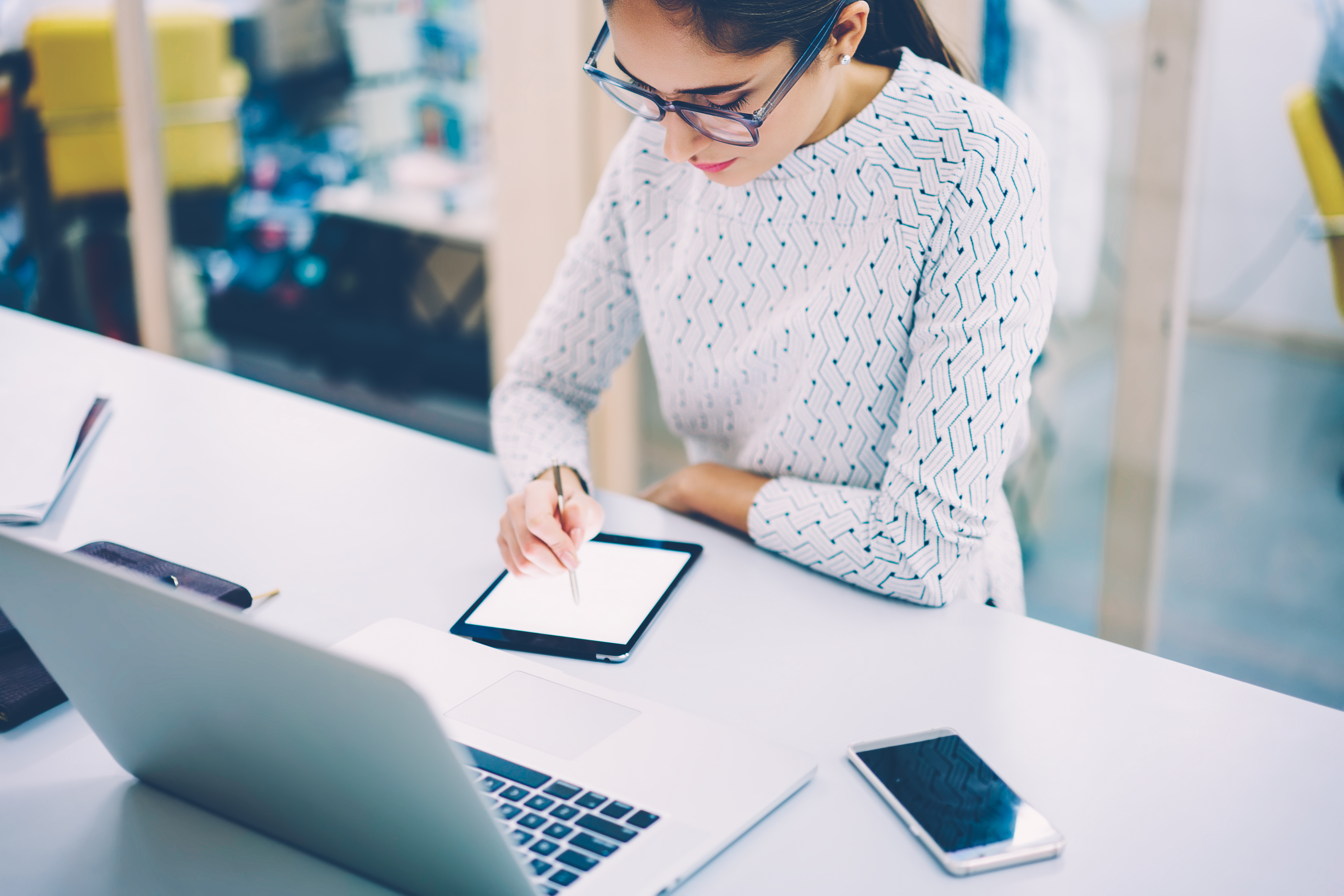 Concentrated female web designer drawing using modern digital gadget for synchronizing sketch with laptop computer,creative woman working as illustrator painting on blank tablet with pen in office SAPHIR Cimetières